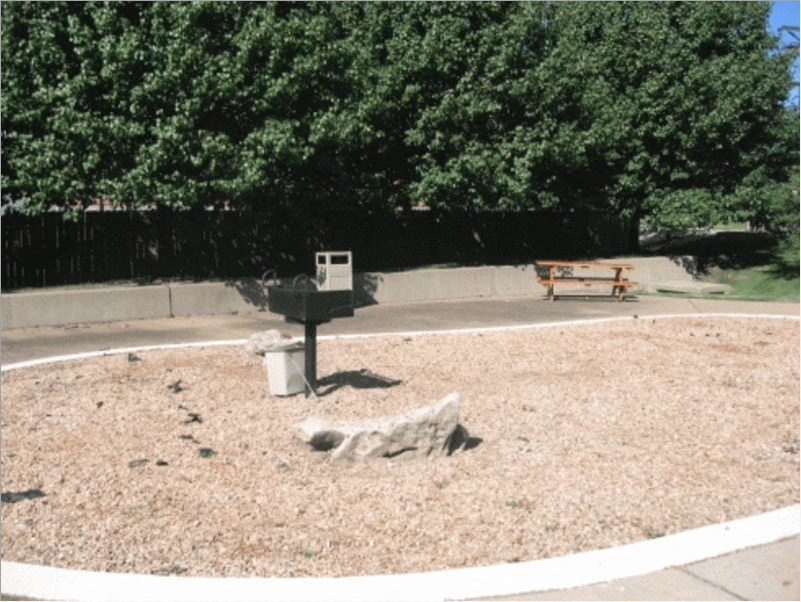 a park with a grill and a picnic table