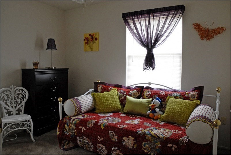 a bedroom with a bed and a dresser and a window