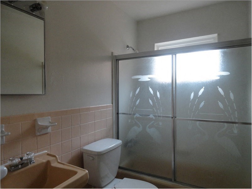 a bathroom with a shower and a toilet and a sink