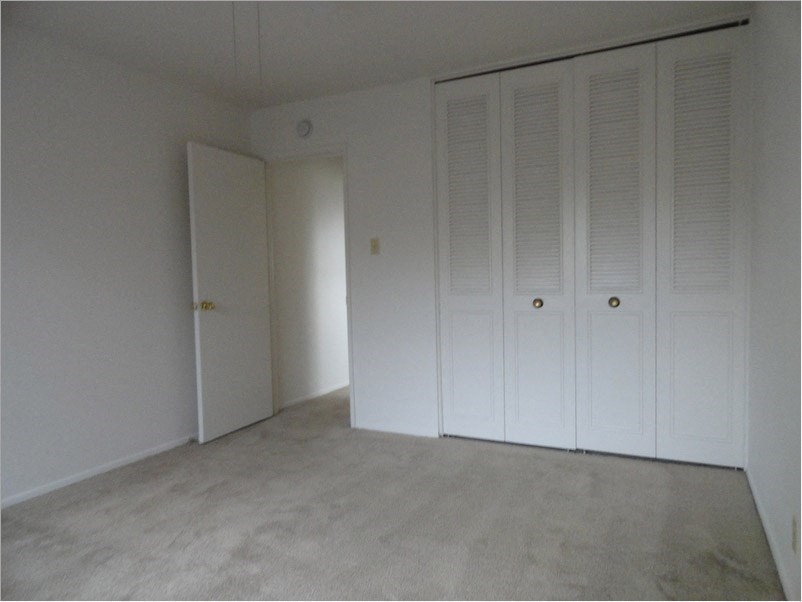 an empty room with white closets on the wall
