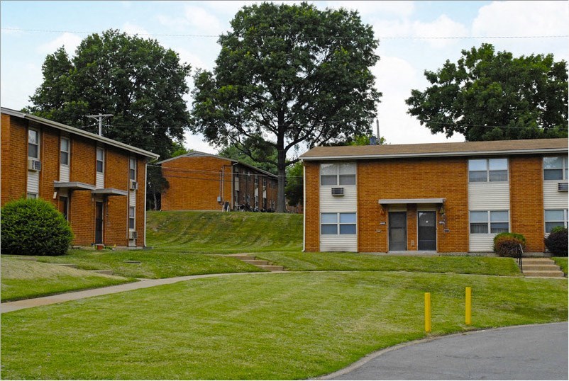 a row of brick apartment buildings on a lawn
