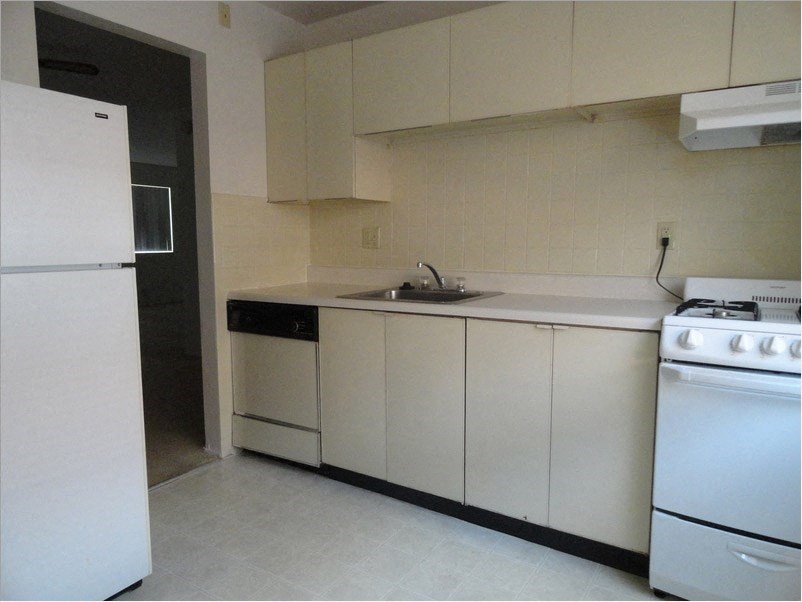 an empty kitchen with a stove and a sink