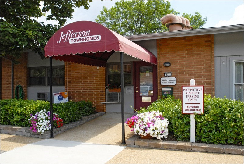 a building with a red awning and flowers in front of it