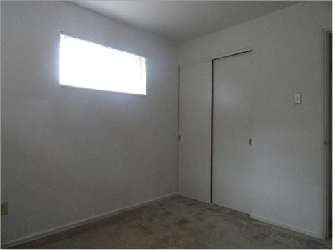 an empty room with a window and a door