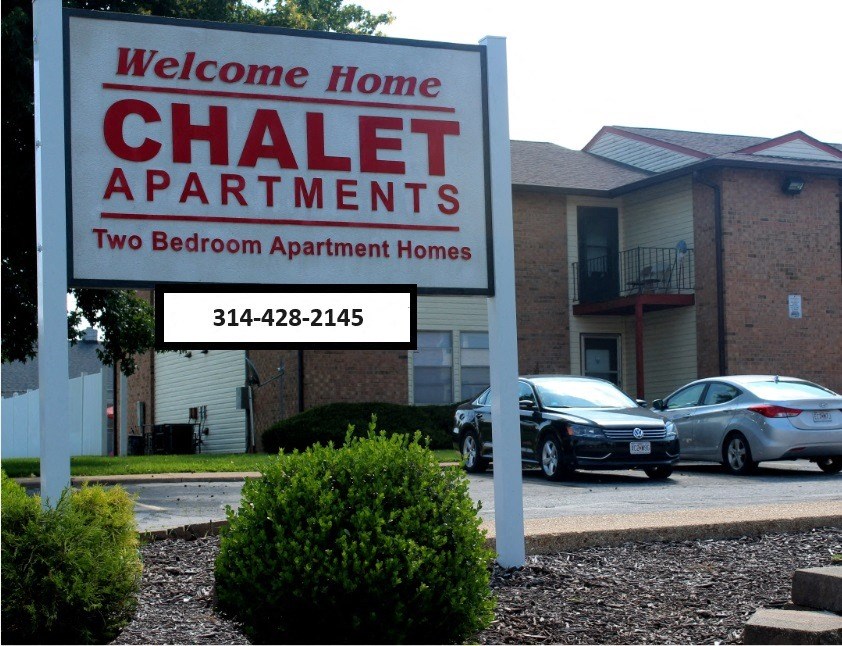 a sign apartments in front of a parking lot