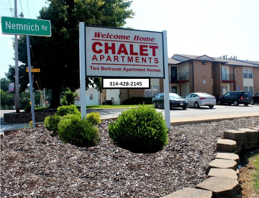 a sign apartments in front of a street