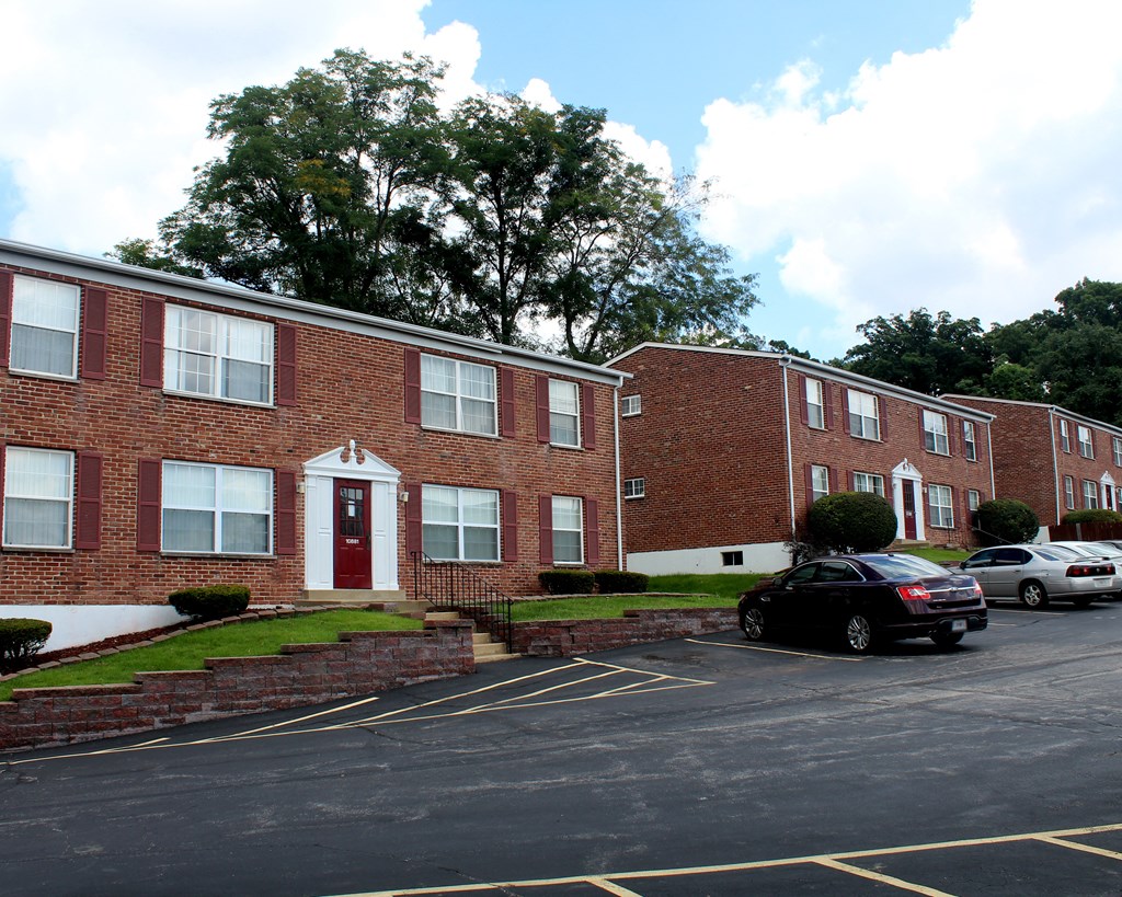 a parking lot in front of a brick apartment building