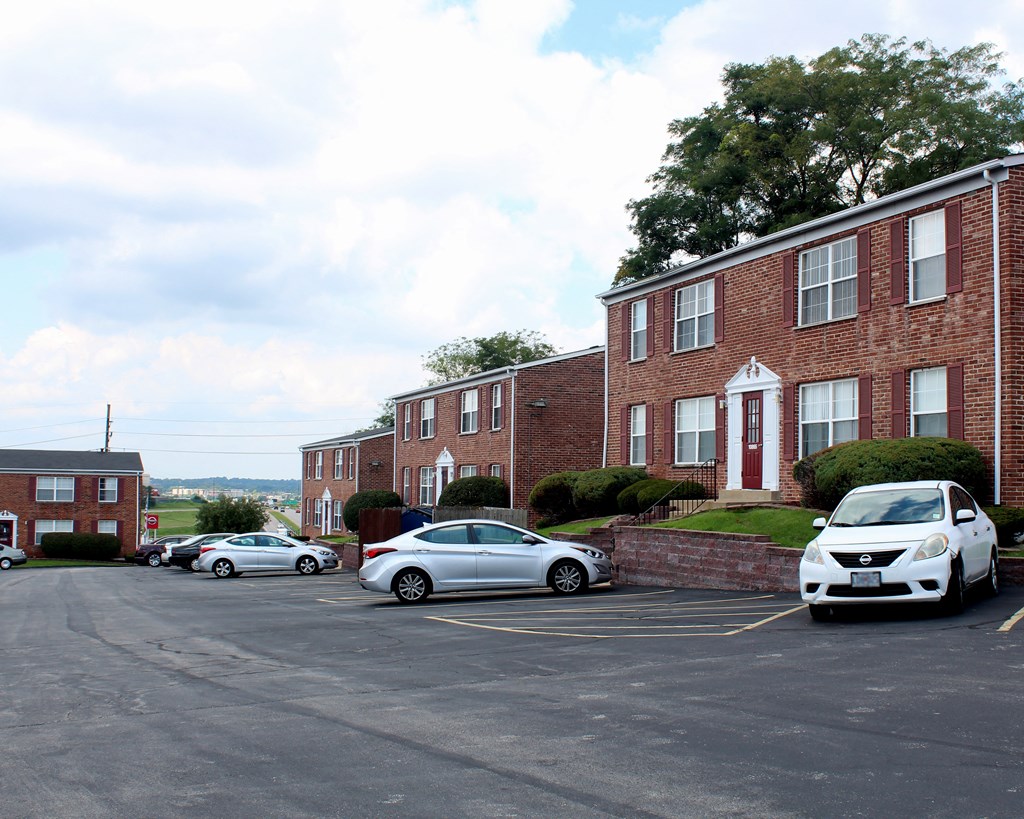 a parking lot with cars parked in front of a brick building