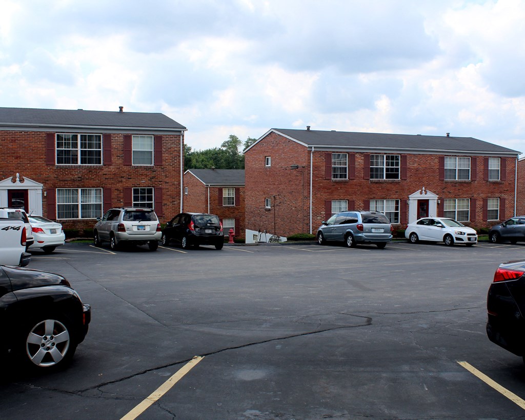 a parking lot in front of a brick apartment building