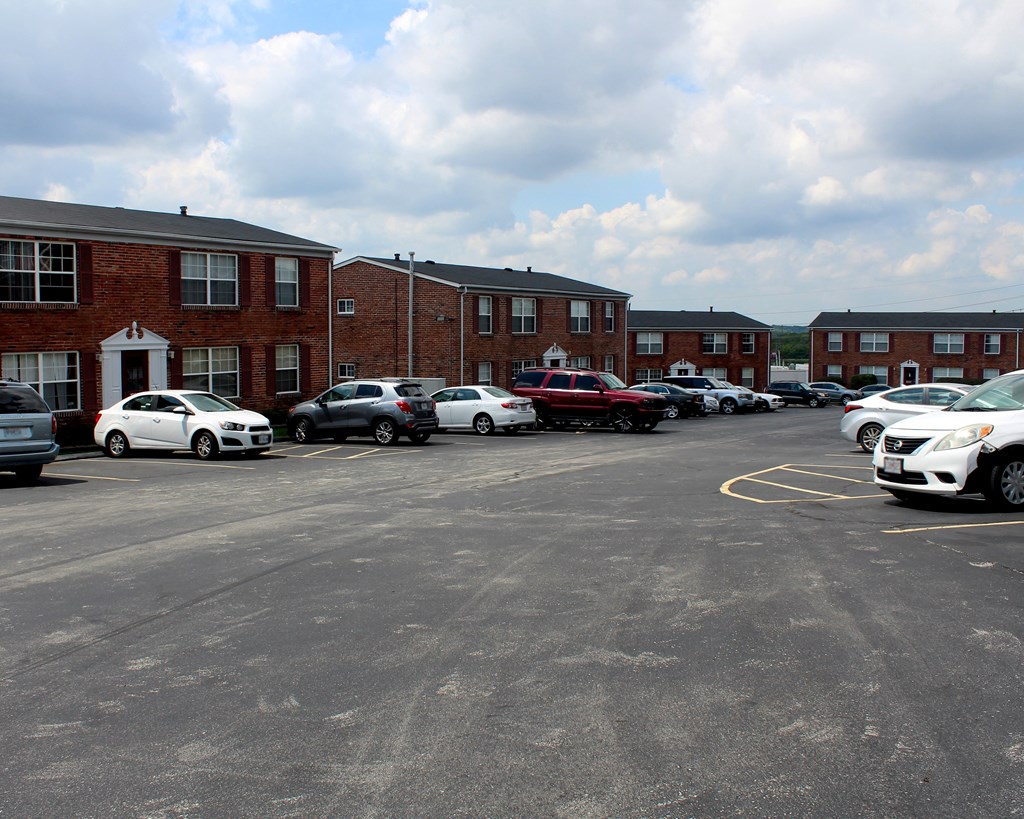 a parking lot filled with cars in front of a brick building