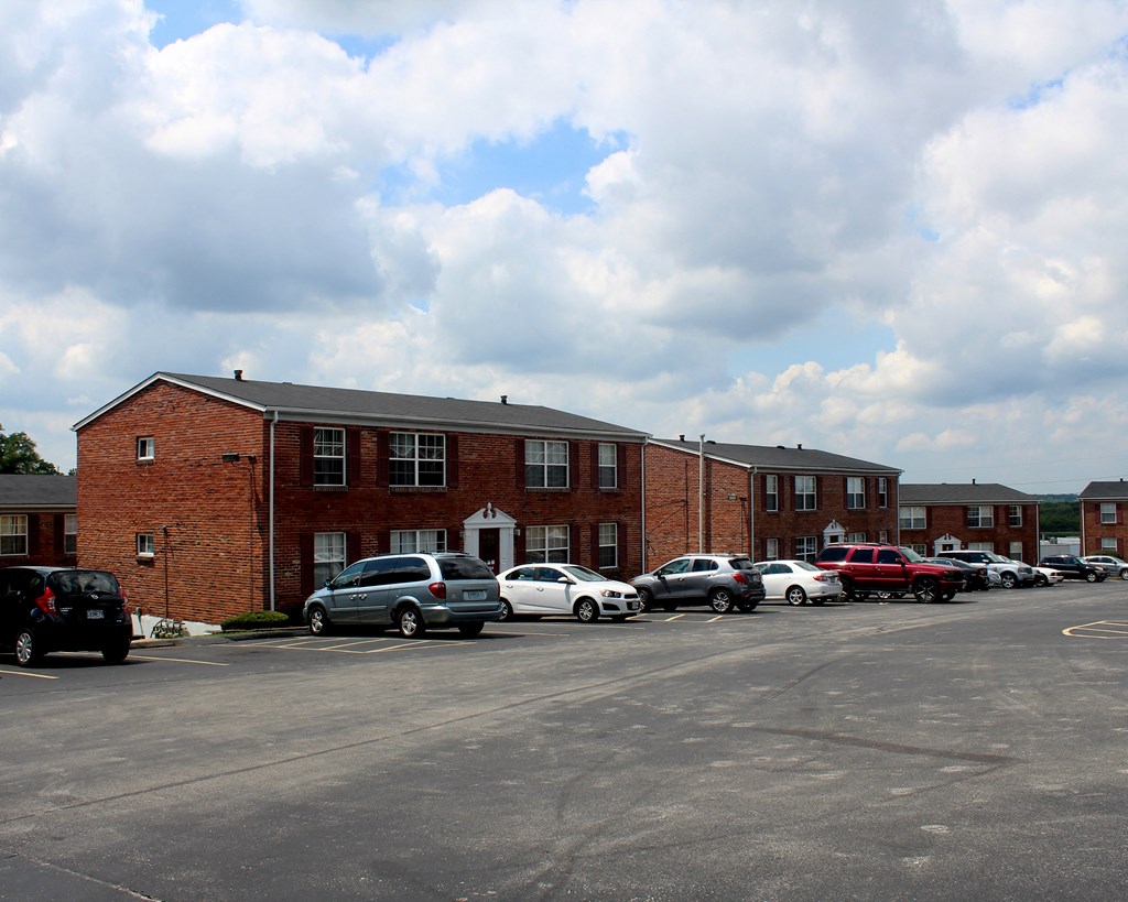 a parking lot with cars in front of a brick building