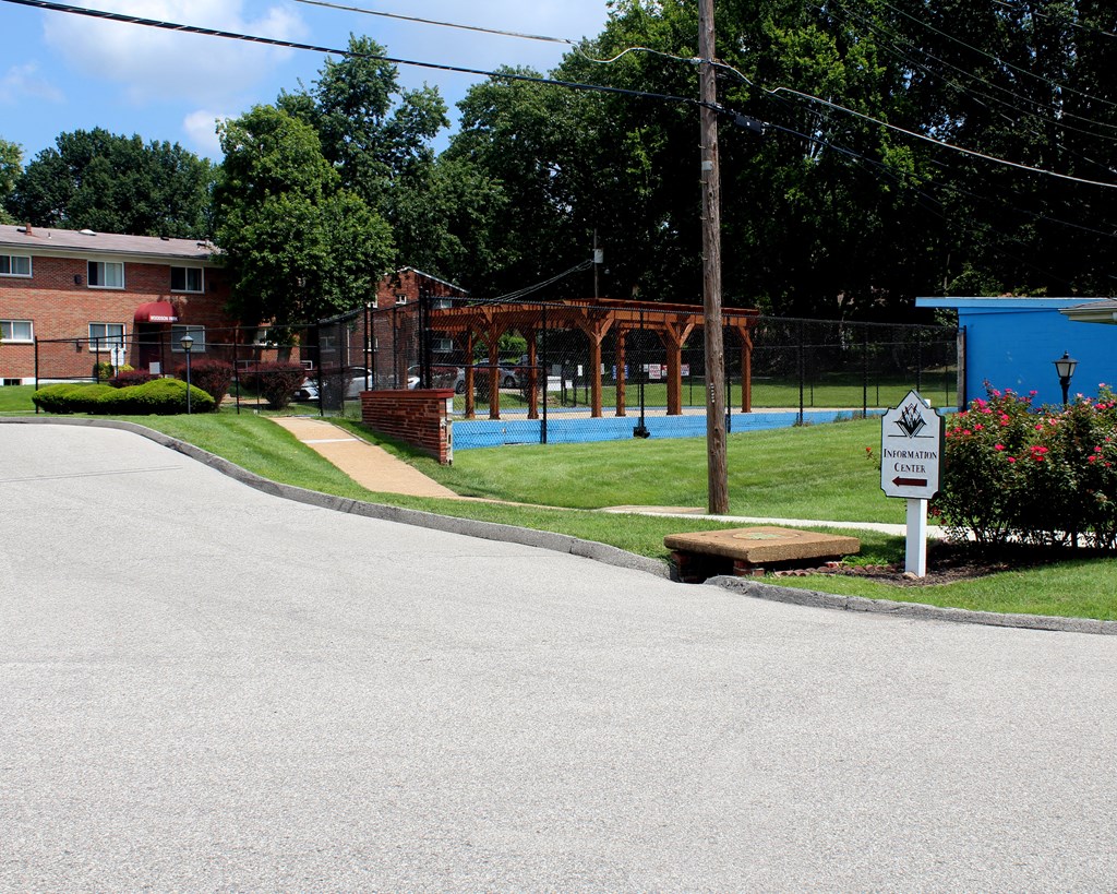 a park with a pool and a sign in front of a house