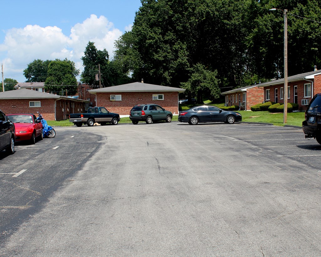 a parking lot with cars in front of a brick building