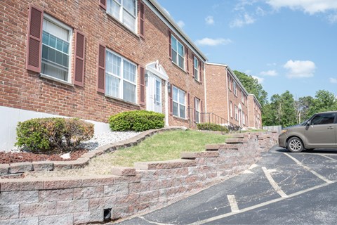A brick building with a car parked in front.
