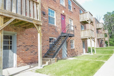 A red brick building with a wooden balcony and stairs.