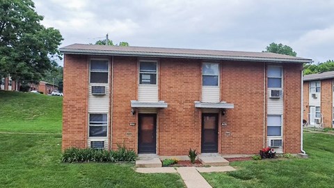 A brick building with a green lawn in front.