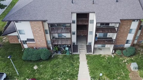 A large apartment complex with a grassy courtyard in the front.