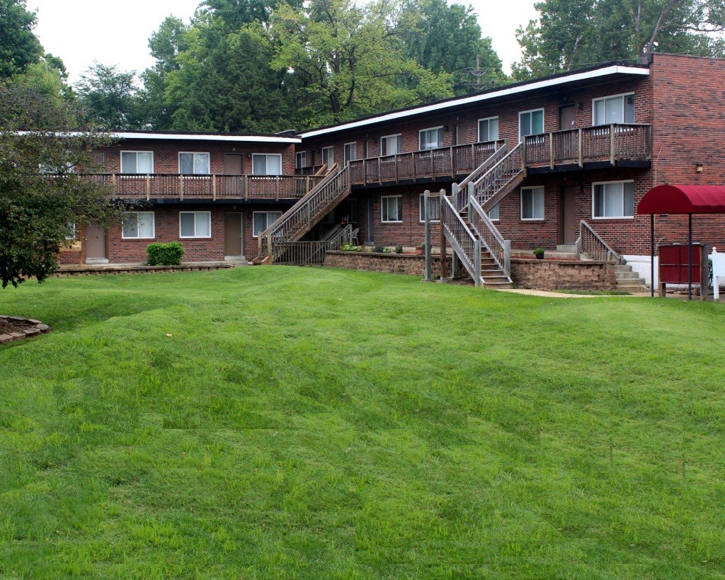 the courtyard of an apartment building with a green lawn
