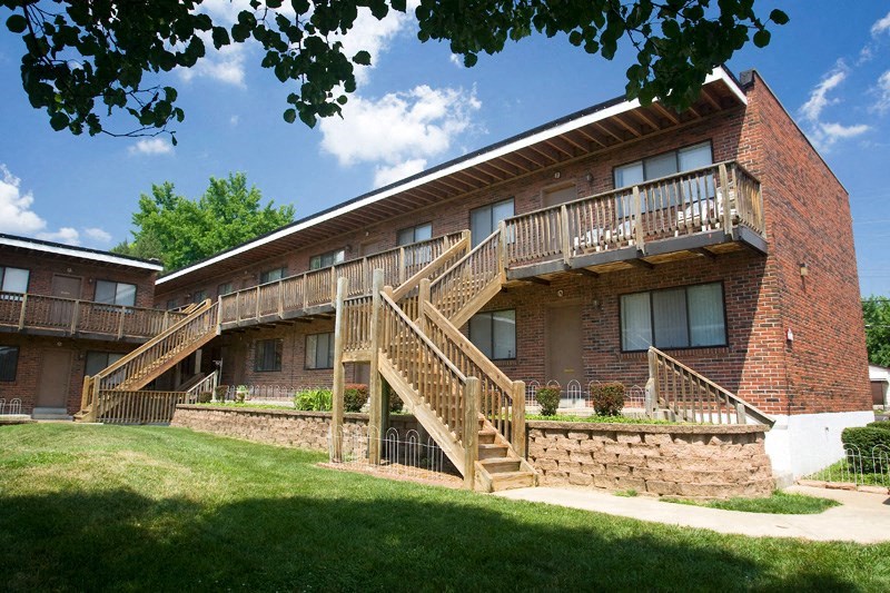 the front of a brick building with a wooden staircase