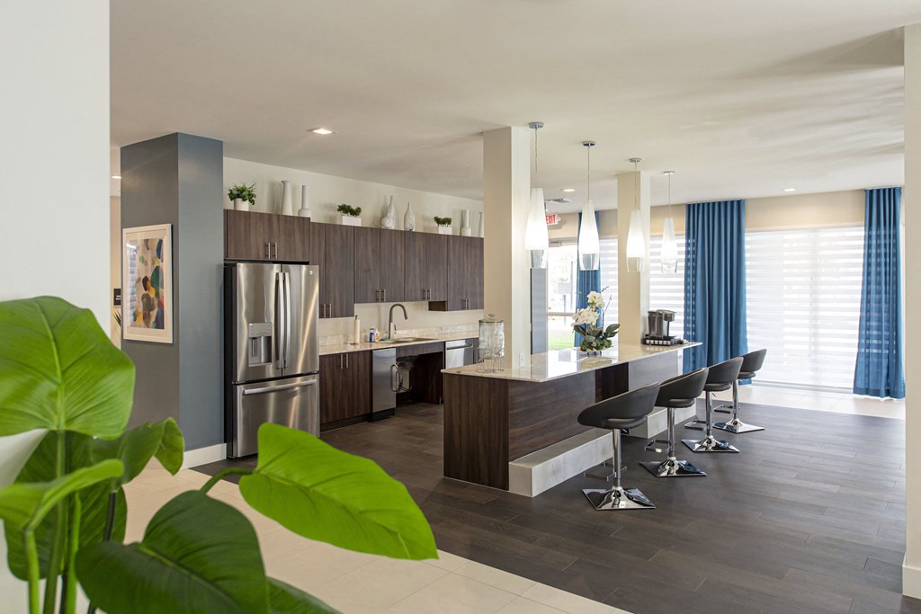 a kitchen with a large island and a stainless steel refrigerator