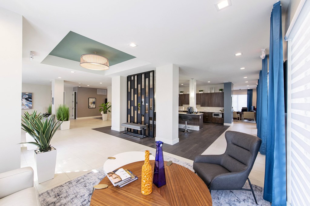 a living room with a wooden table and chairs and a kitchen in the background
