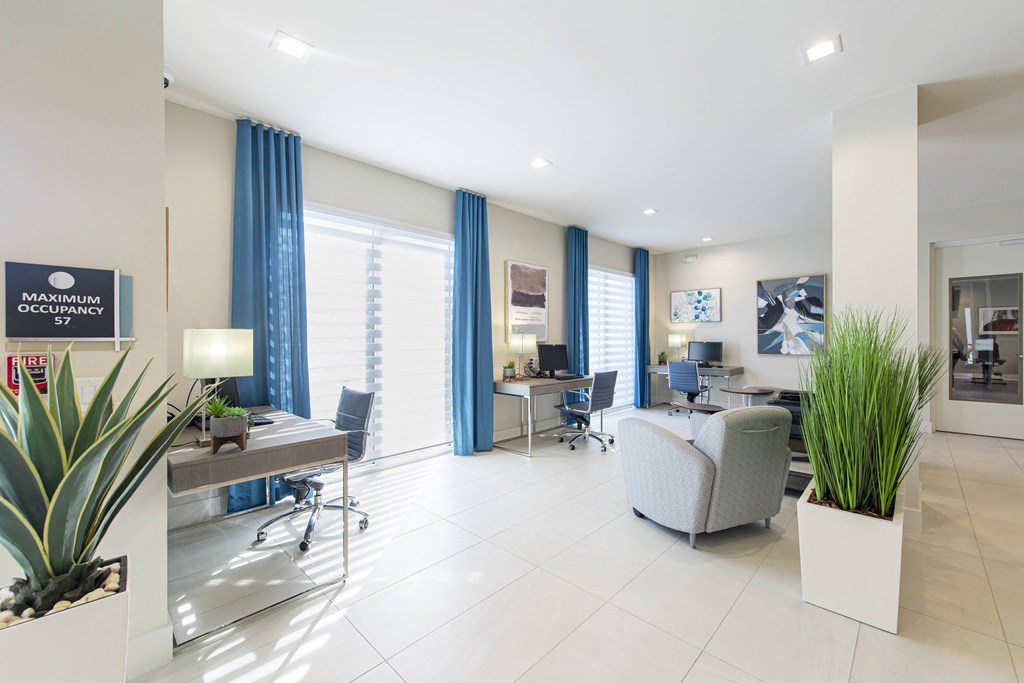 a living room with a couch and chairs and a desk