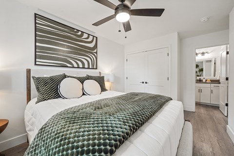 A bedroom with a large bed and a ceiling fan.