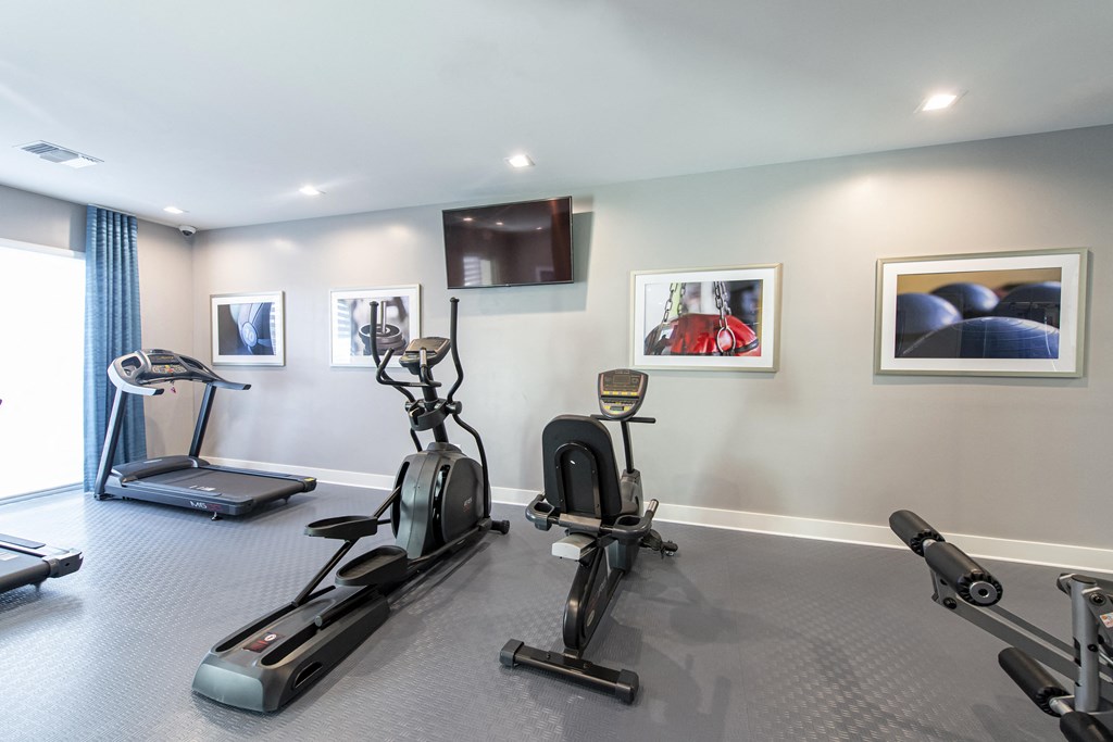 a gym with exercise equipment and paintings on the wall