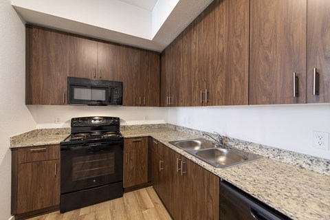 a kitchen with wood cabinets and granite counter tops and a stove and sink