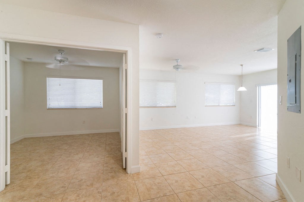 an empty living room and dining room with a tile floor