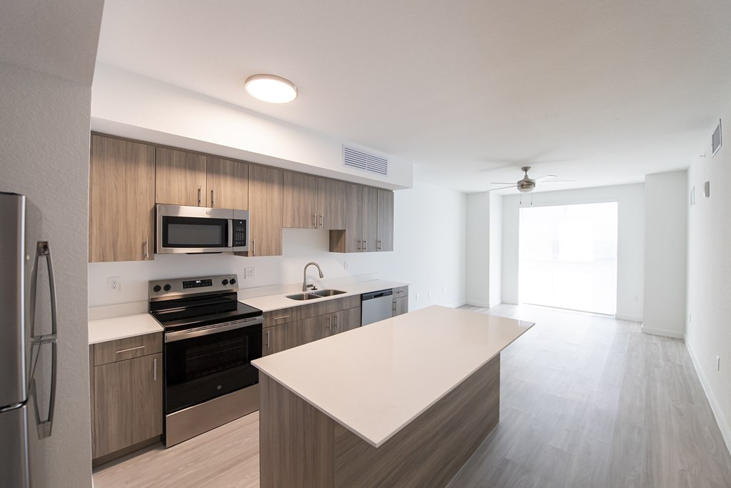 A modern kitchen with a refrigerator, stove, and microwave.