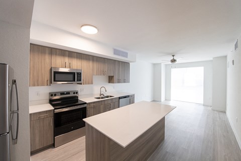 A modern kitchen with a refrigerator, stove, and microwave.