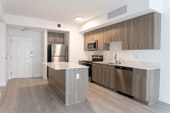 A modern kitchen with stainless steel appliances and wooden cabinets.