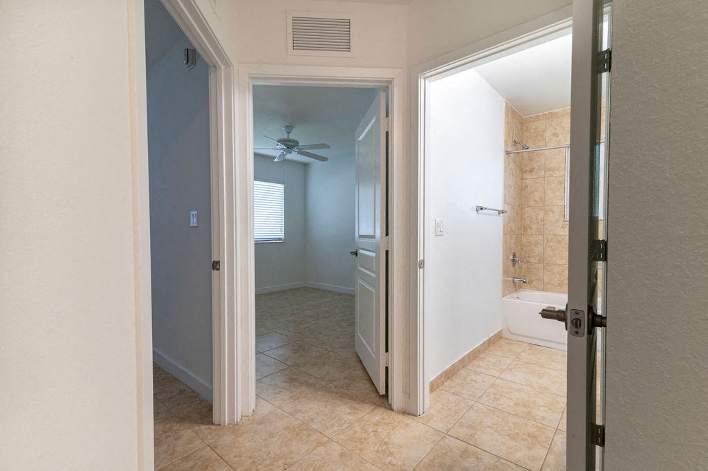 a bathroom with a shower and a door open