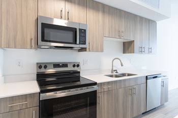 A modern kitchen with a stove, oven, microwave, and sink.