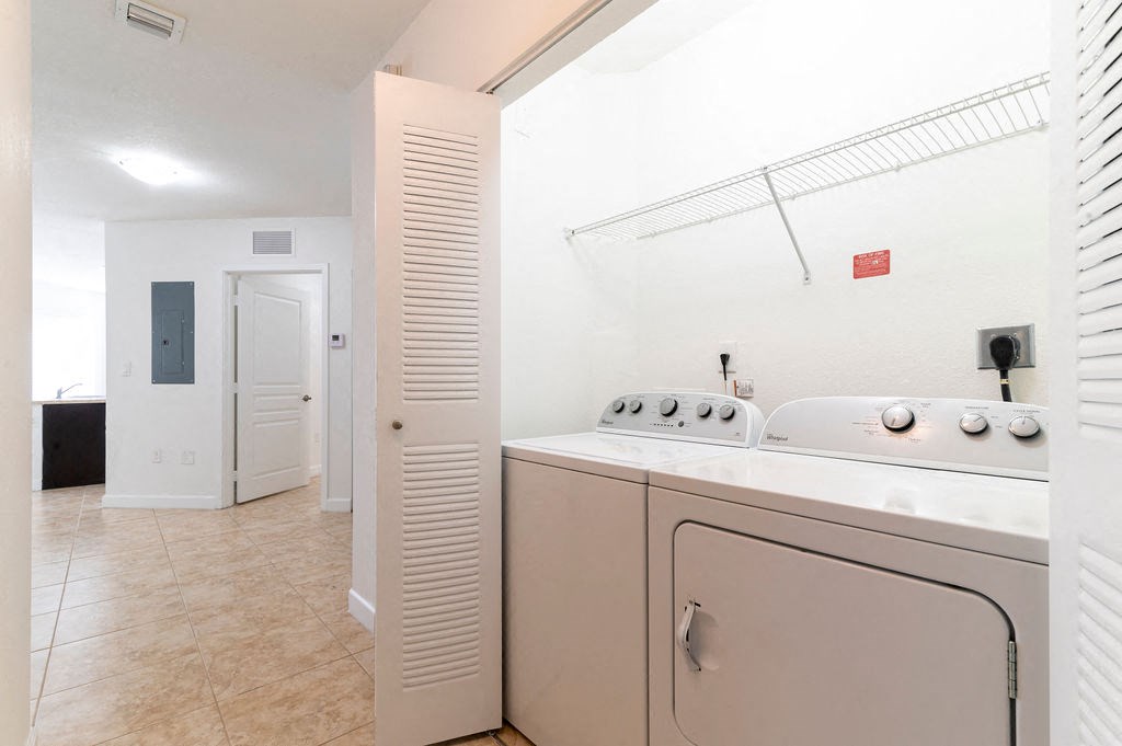 a washer and dryer in a laundry room with a door to a bathroom