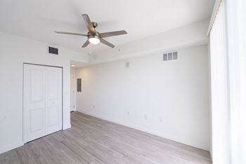 A room with a ceiling fan and a door.