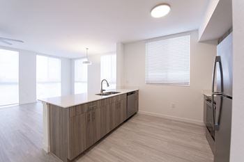 A kitchen with a refrigerator on the right side.