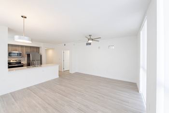 A spacious room with a ceiling fan and light fixture.