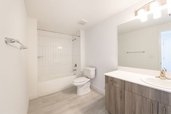 A white bathroom with a toilet, sink, and shower.