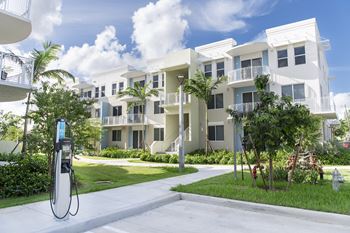 A white building with a parking area in front.