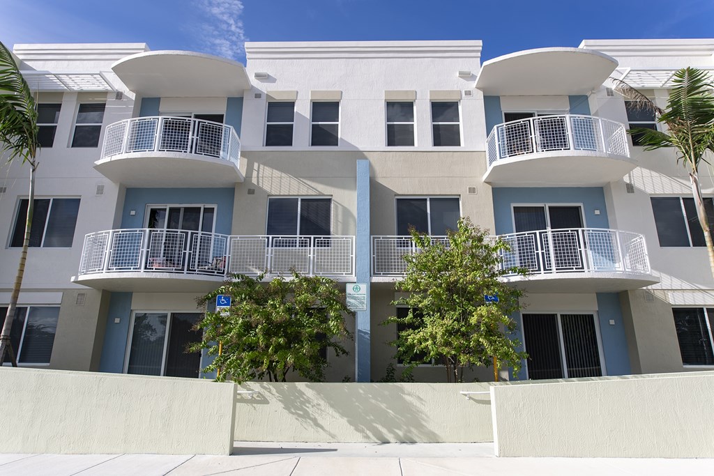 A white building with blue trim and balconies.
