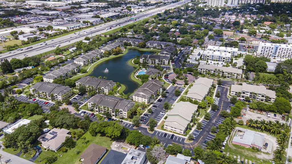 A bird's eye view of a residential area with a lake in the middle.
