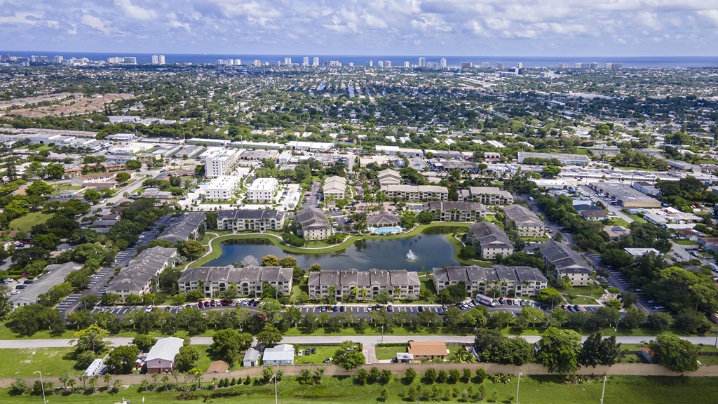 A bird's eye view of a residential area with a swimming pool and apartment buildings.