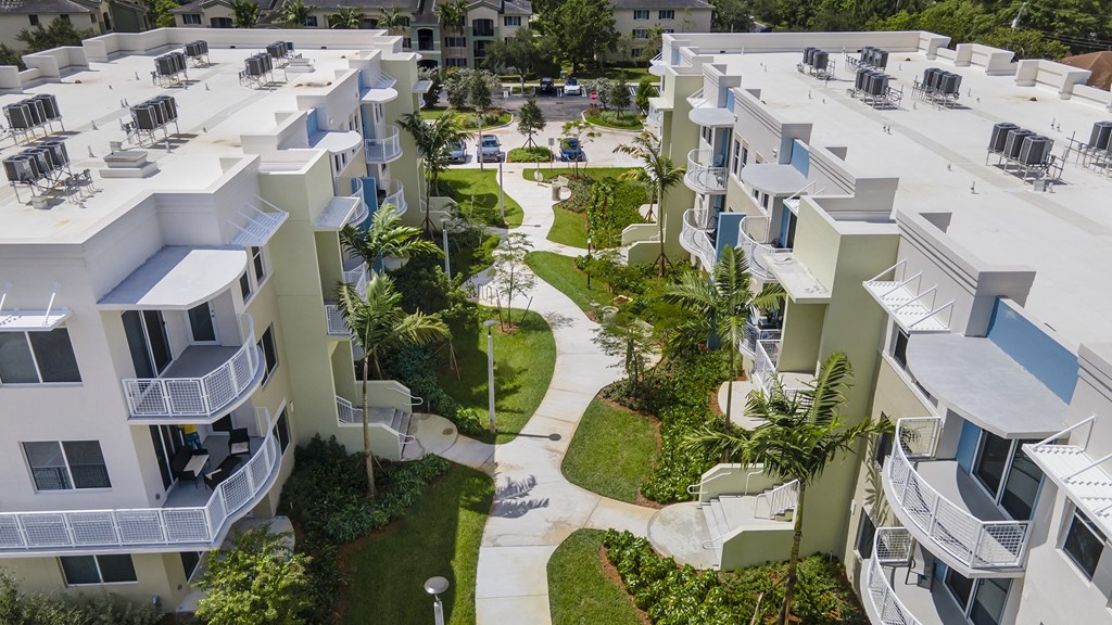 Apartment complex with green lawns and trees.