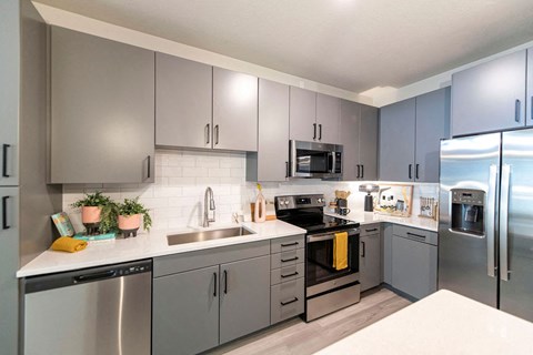 a kitchen with stainless steel appliances and gray cabinets