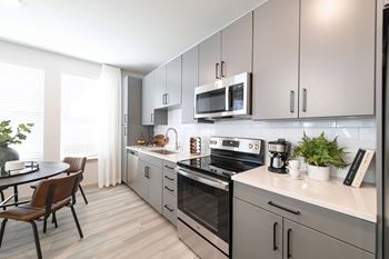 A modern kitchen with a wooden table and chairs.