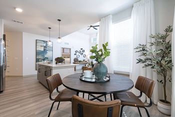 A dining room with a round table and chairs.