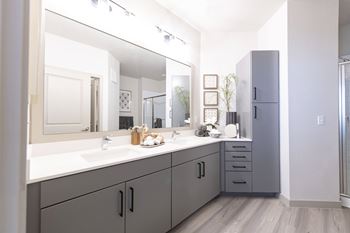 A bathroom with a vanity and a large mirror.