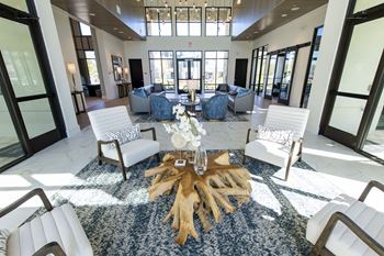 A large room with a blue rug and a wooden coffee table.